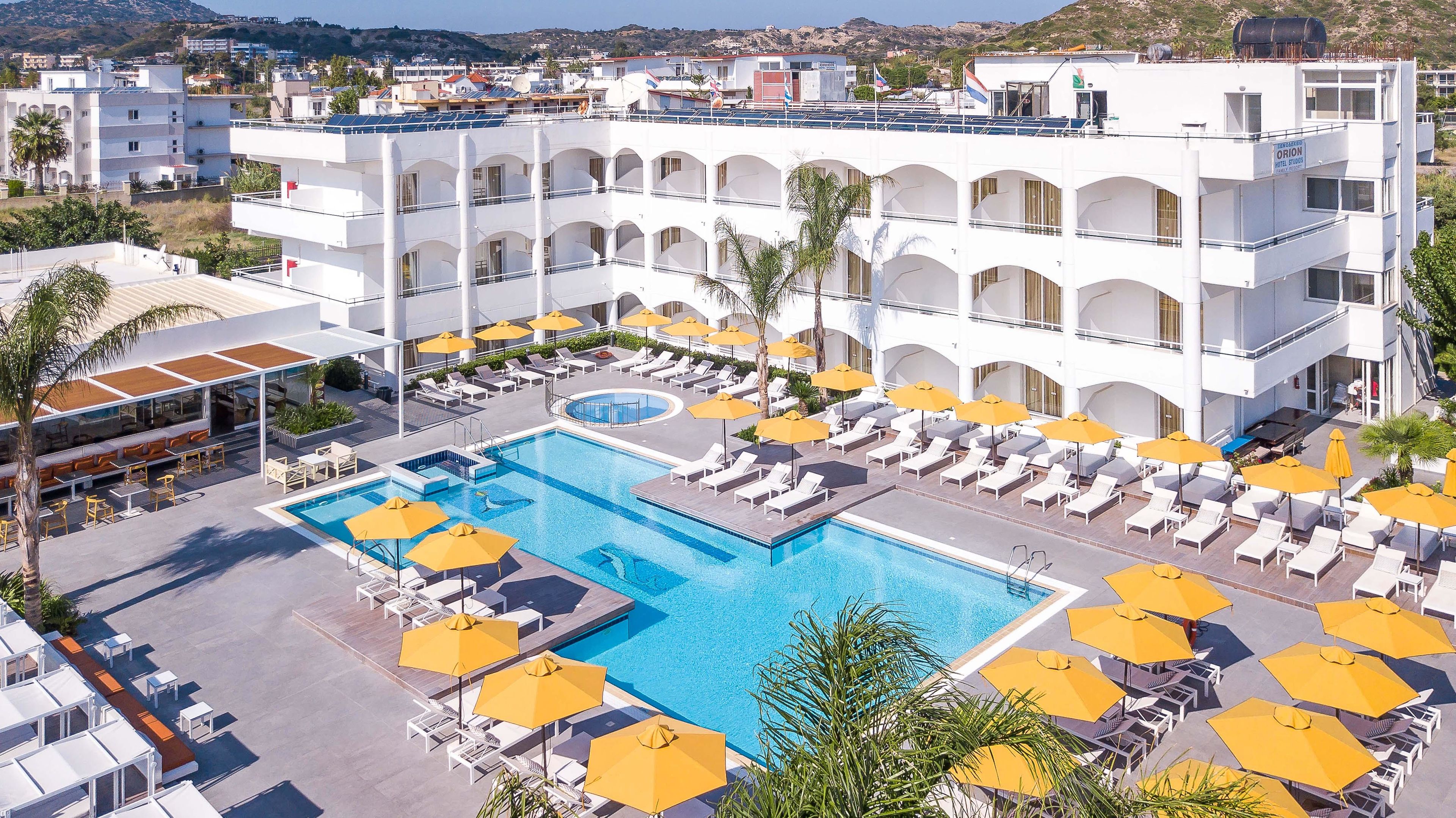 Wit hotel met zwembad en ligbedden
